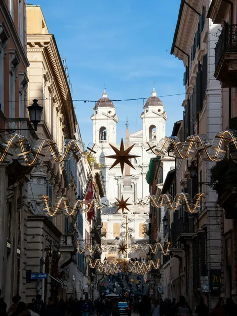 Calle de Roma con una estrella luminosa cruzando entre edificios